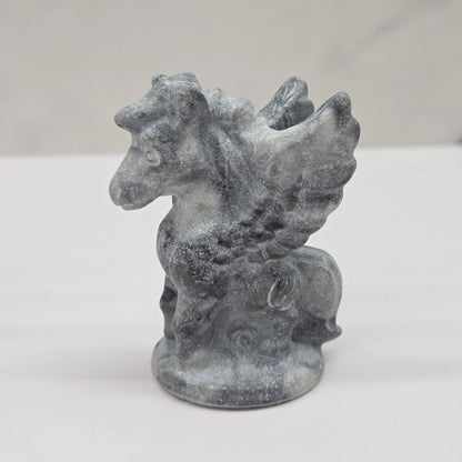 Stone sculpture of a winged creature on a white background