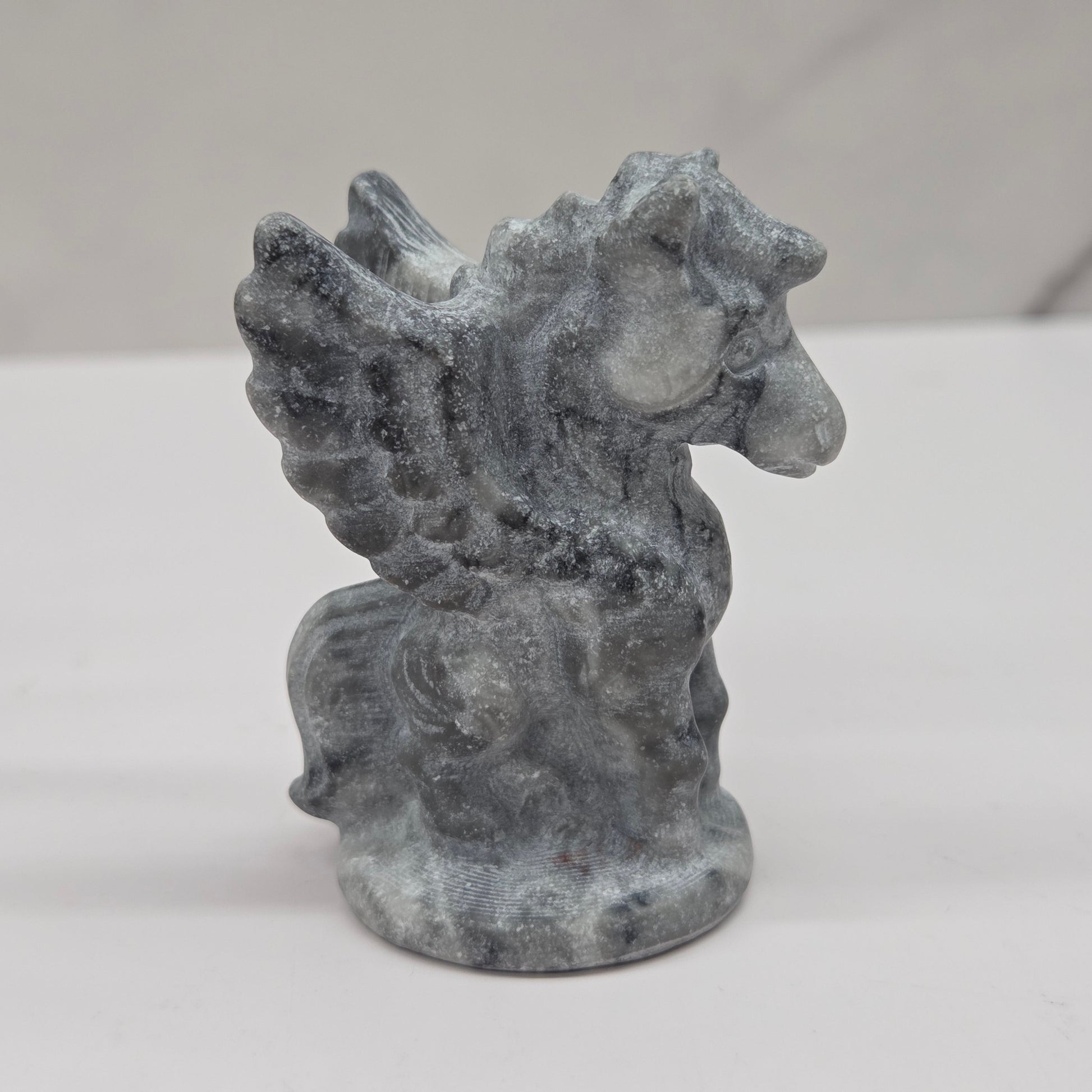Stone sculpture of a winged creature on a white background