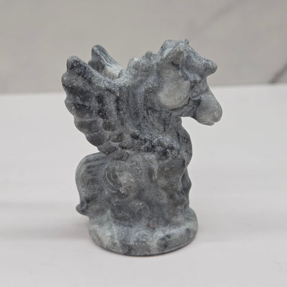 Stone sculpture of a winged creature on a white background