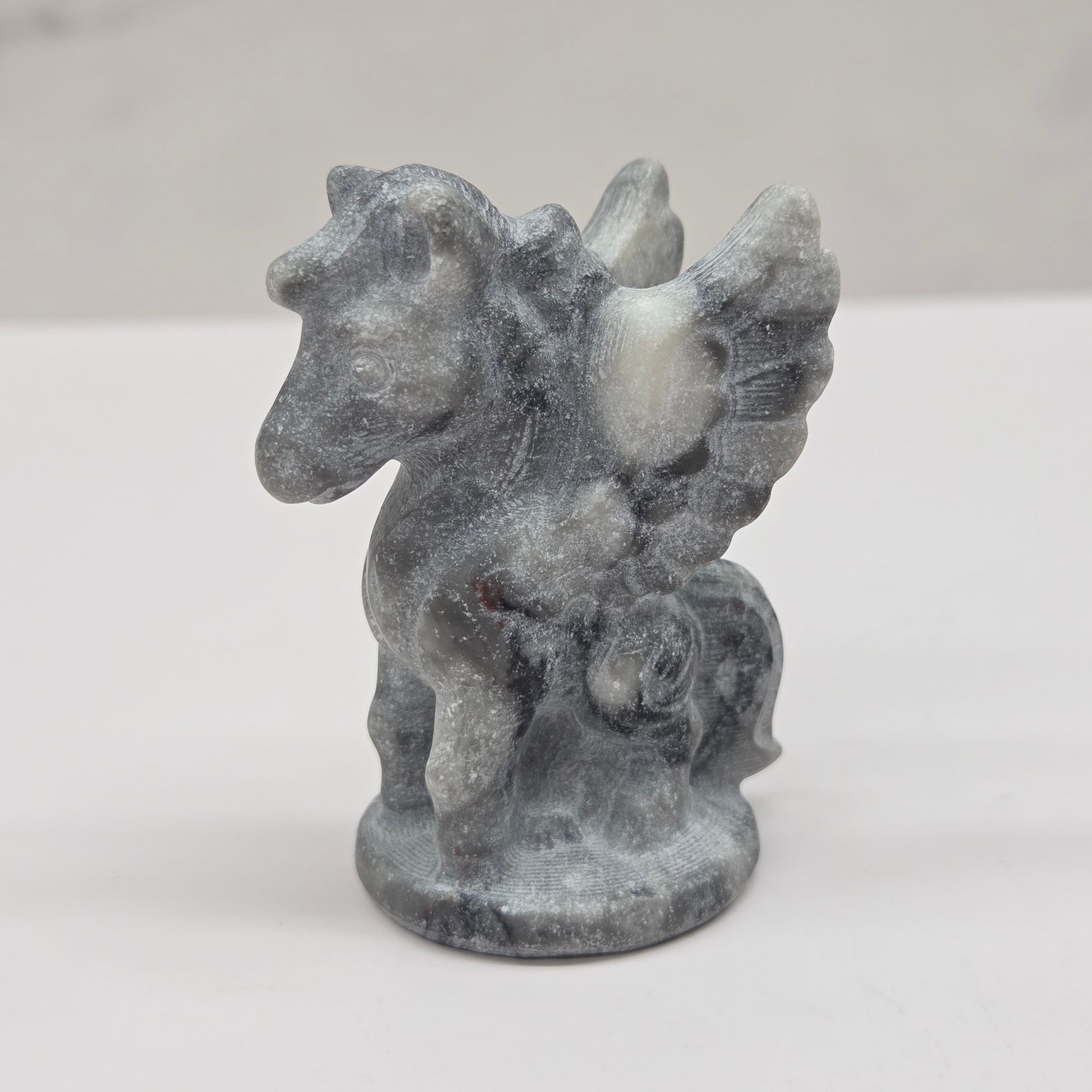Stone sculpture of a winged creature on a white background