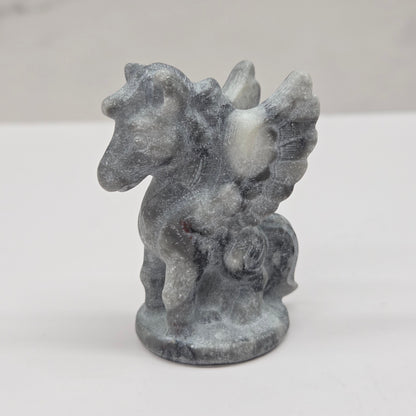 Stone sculpture of a winged creature on a white background
