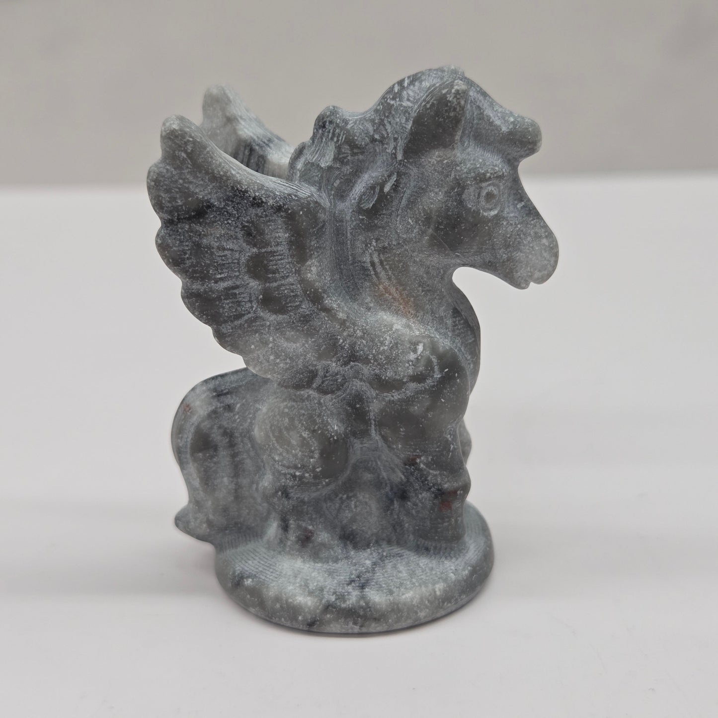 Stone sculpture of a winged creature on a white background