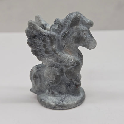 Stone sculpture of a winged creature on a white background