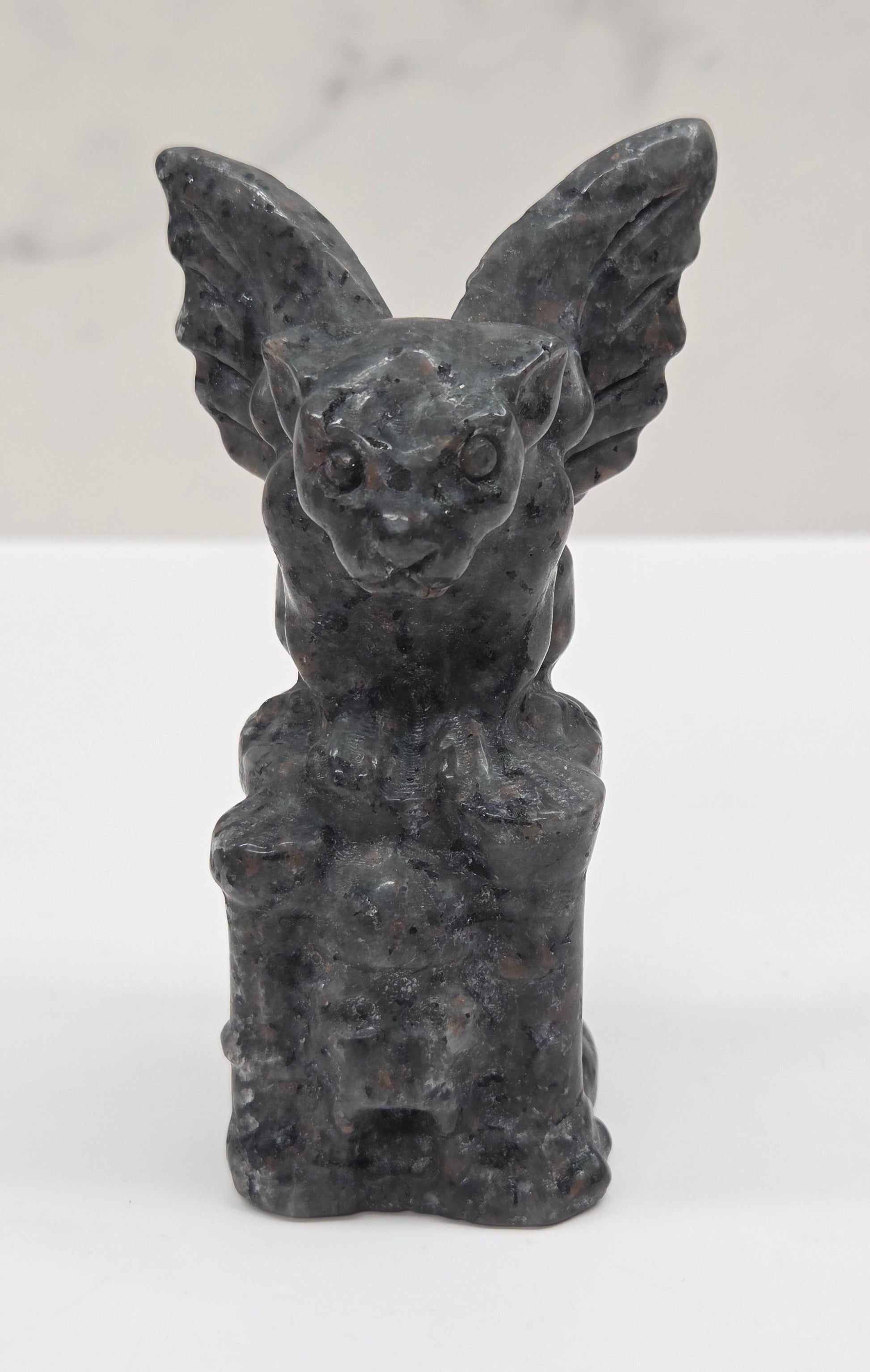 Yooperlite gargoyle carving on a white surface