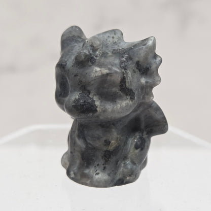Larvikite dragon carving on an acrylic stand against a white background