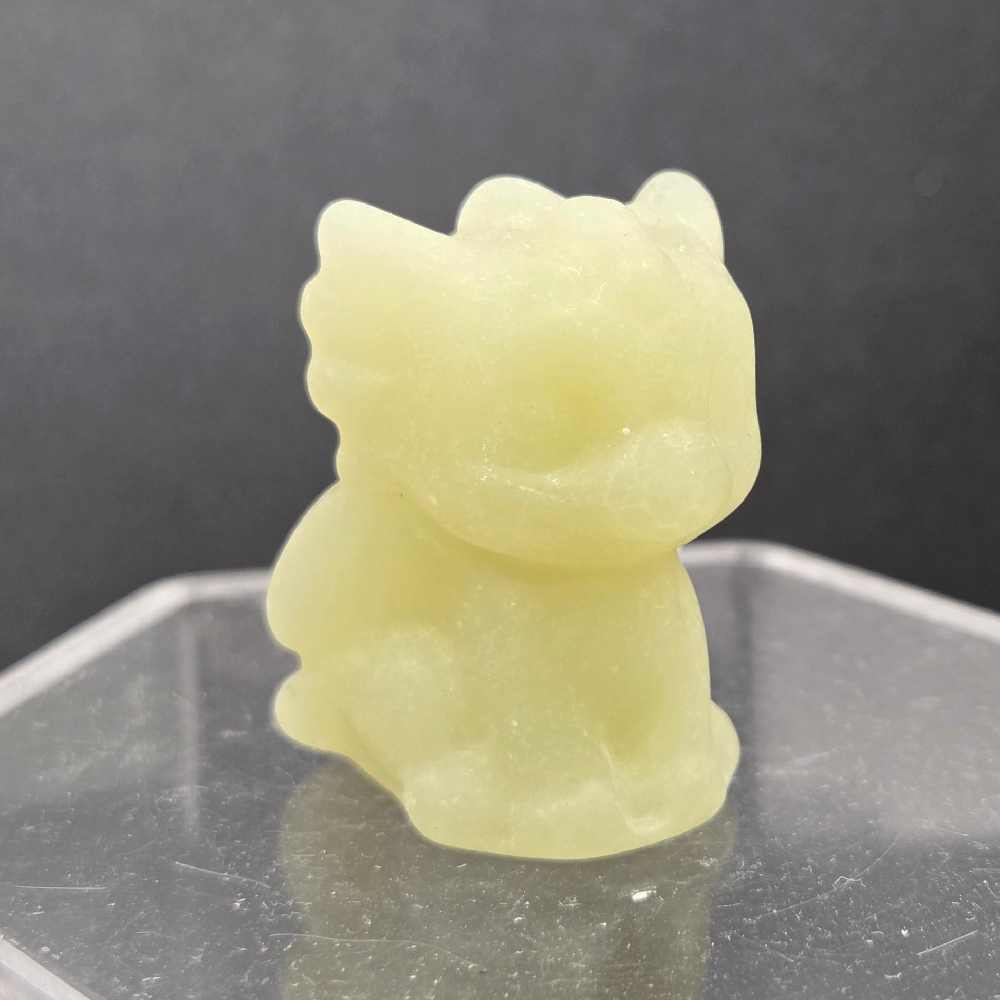 Afghan Jade dragon carving on an acrylic stand against a dark background