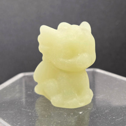 Afghan Jade dragon carving on an acrylic stand against a dark background
