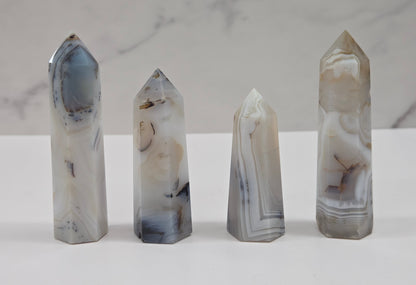 Set of four crystal points on a white surface with a marble-patterned background