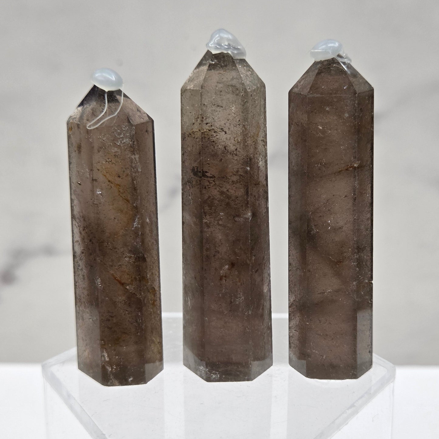 Three smoky quartz towers on a marble surface