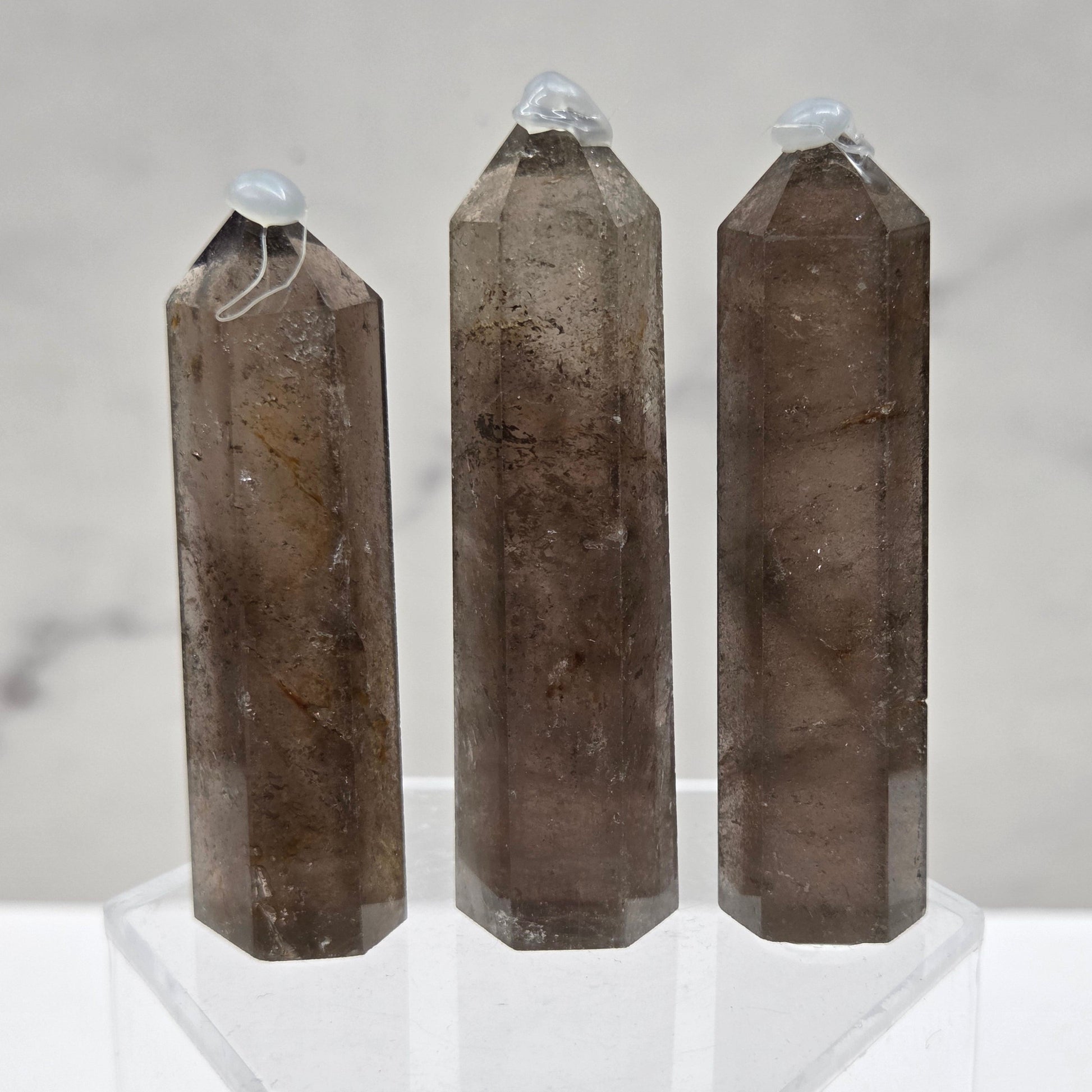 Three smoky quartz towers on a marble surface