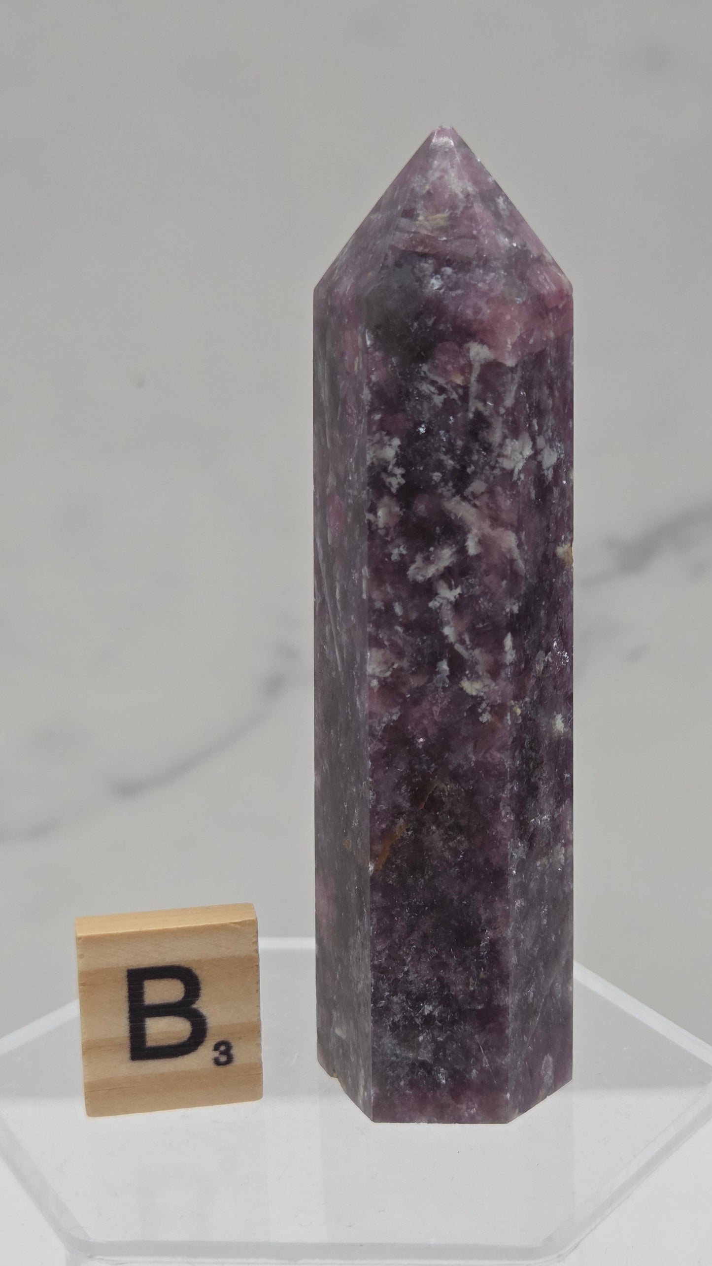 Polished Unicorn Stone crystal towers with varying shades of purple and red, showcasing the natural layered pattern of the stones.