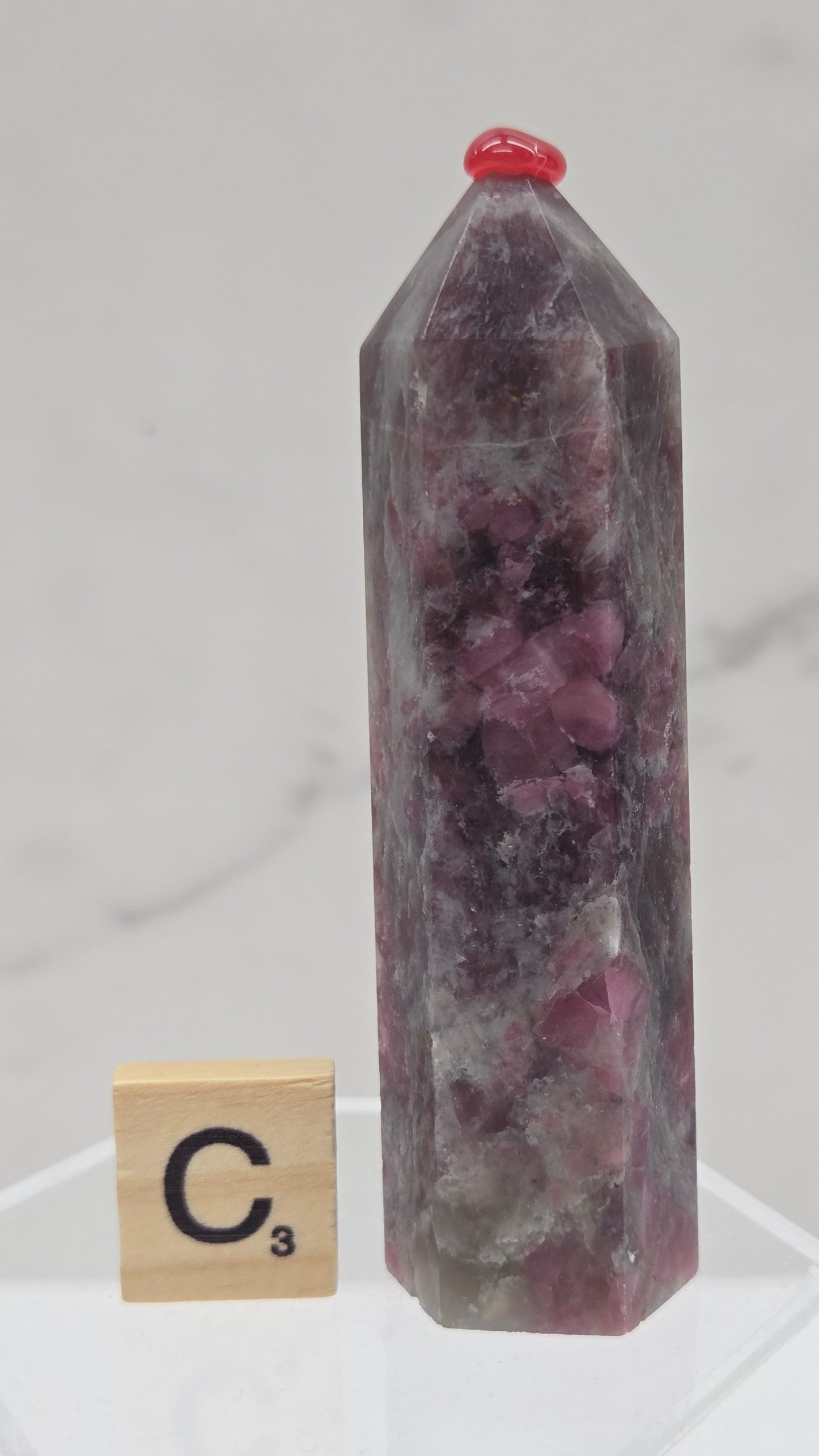 Polished Unicorn Stone crystal towers with varying shades of purple and red, showcasing the natural layered pattern of the stones.