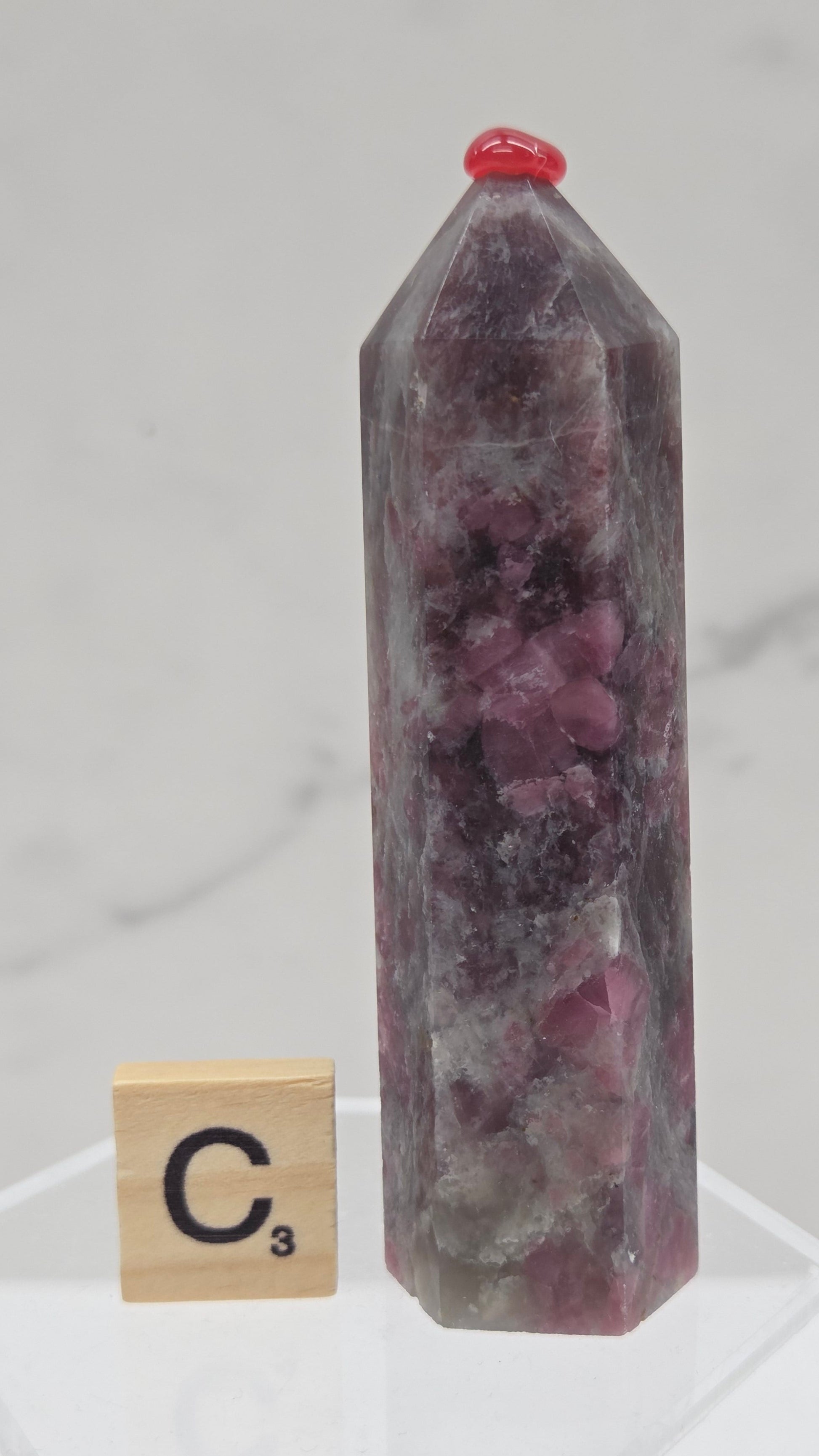Polished Unicorn Stone crystal towers with varying shades of purple and red, showcasing the natural layered pattern of the stones.
