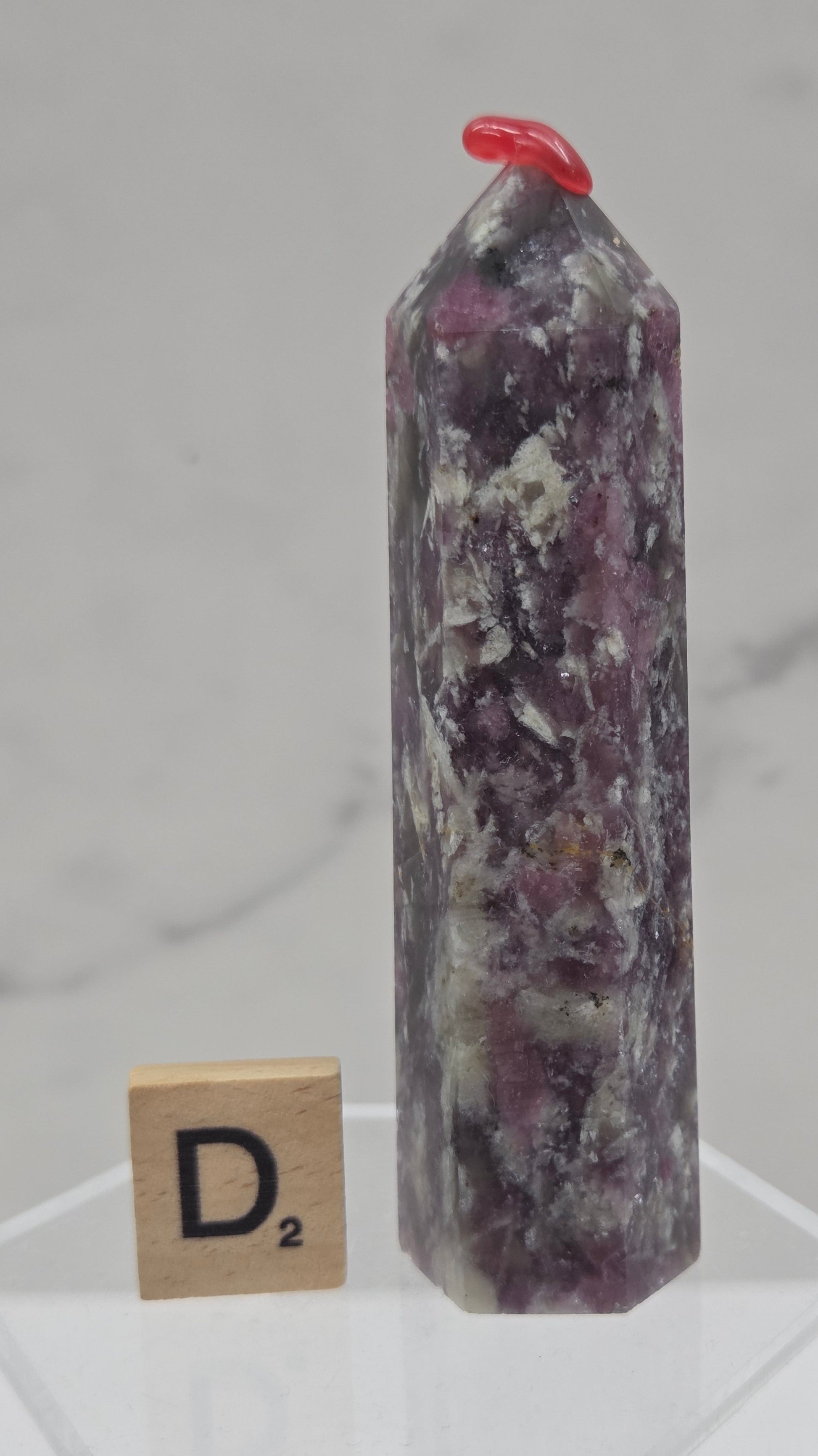 Polished Unicorn Stone crystal towers with varying shades of purple and red, showcasing the natural layered pattern of the stones.