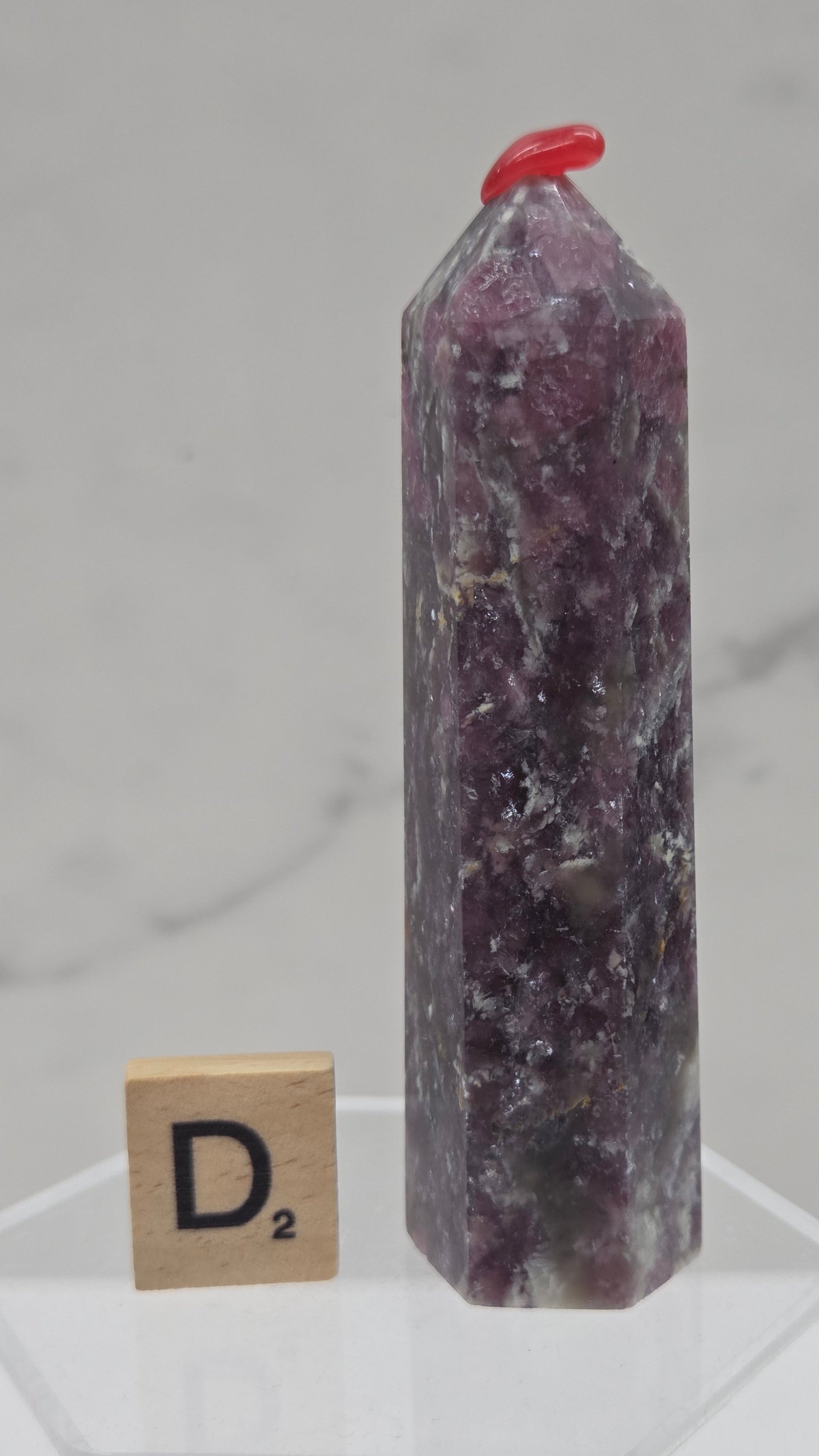 Polished Unicorn Stone crystal towers with varying shades of purple and red, showcasing the natural layered pattern of the stones.