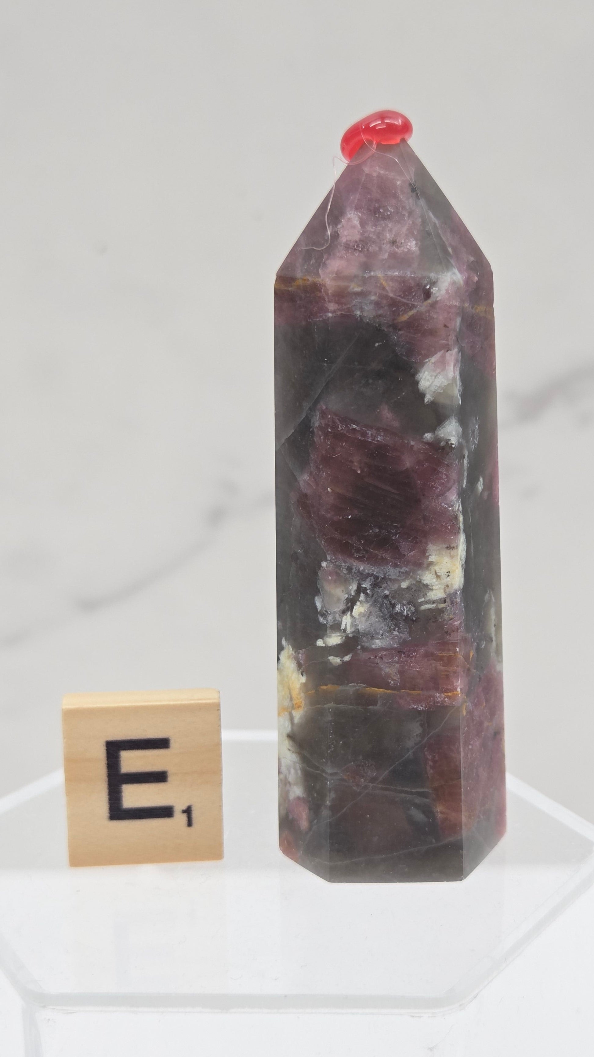 Polished Unicorn Stone crystal towers with varying shades of purple and red, showcasing the natural layered pattern of the stones.