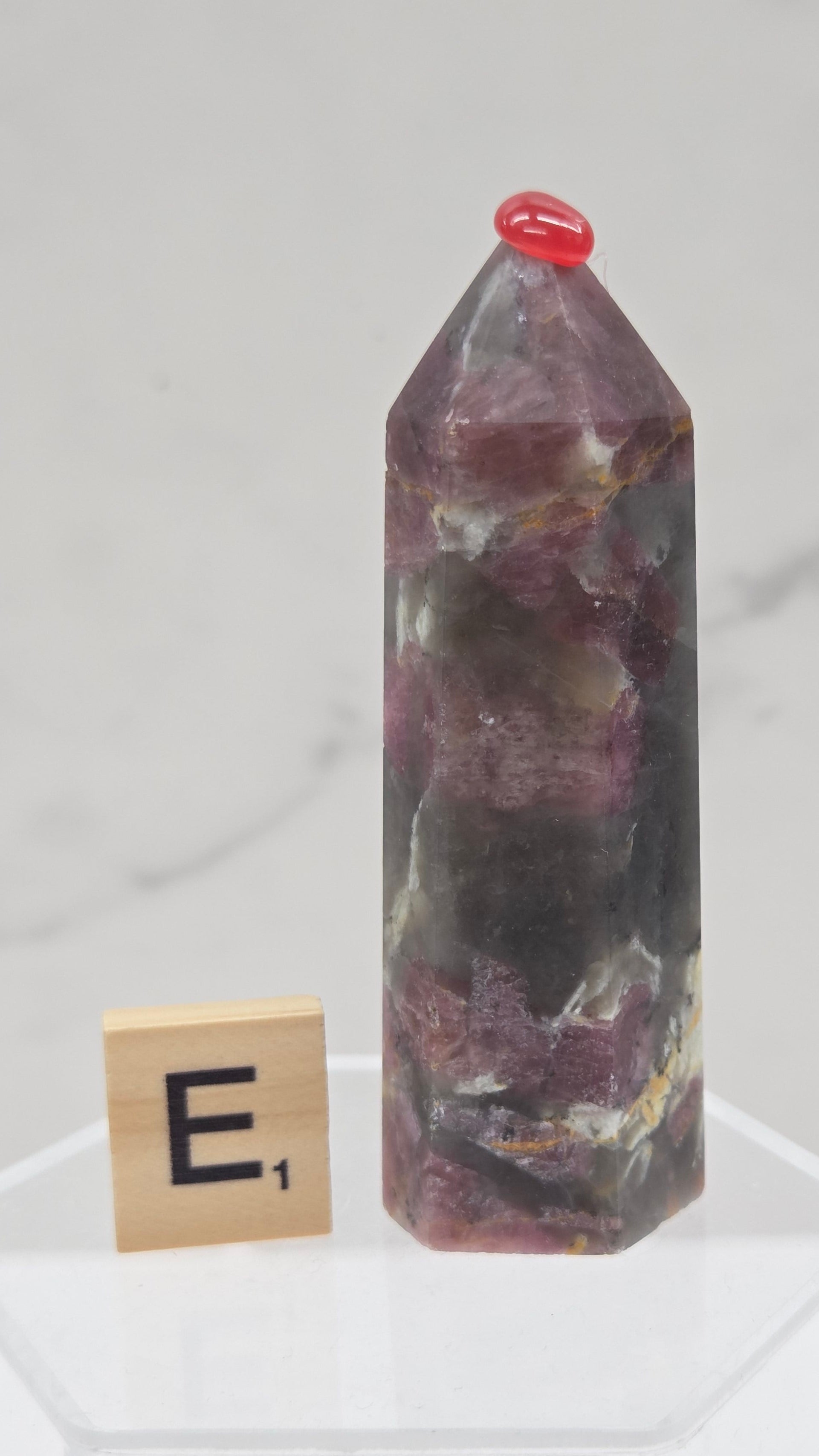 Polished Unicorn Stone crystal towers with varying shades of purple and red, showcasing the natural layered pattern of the stones.