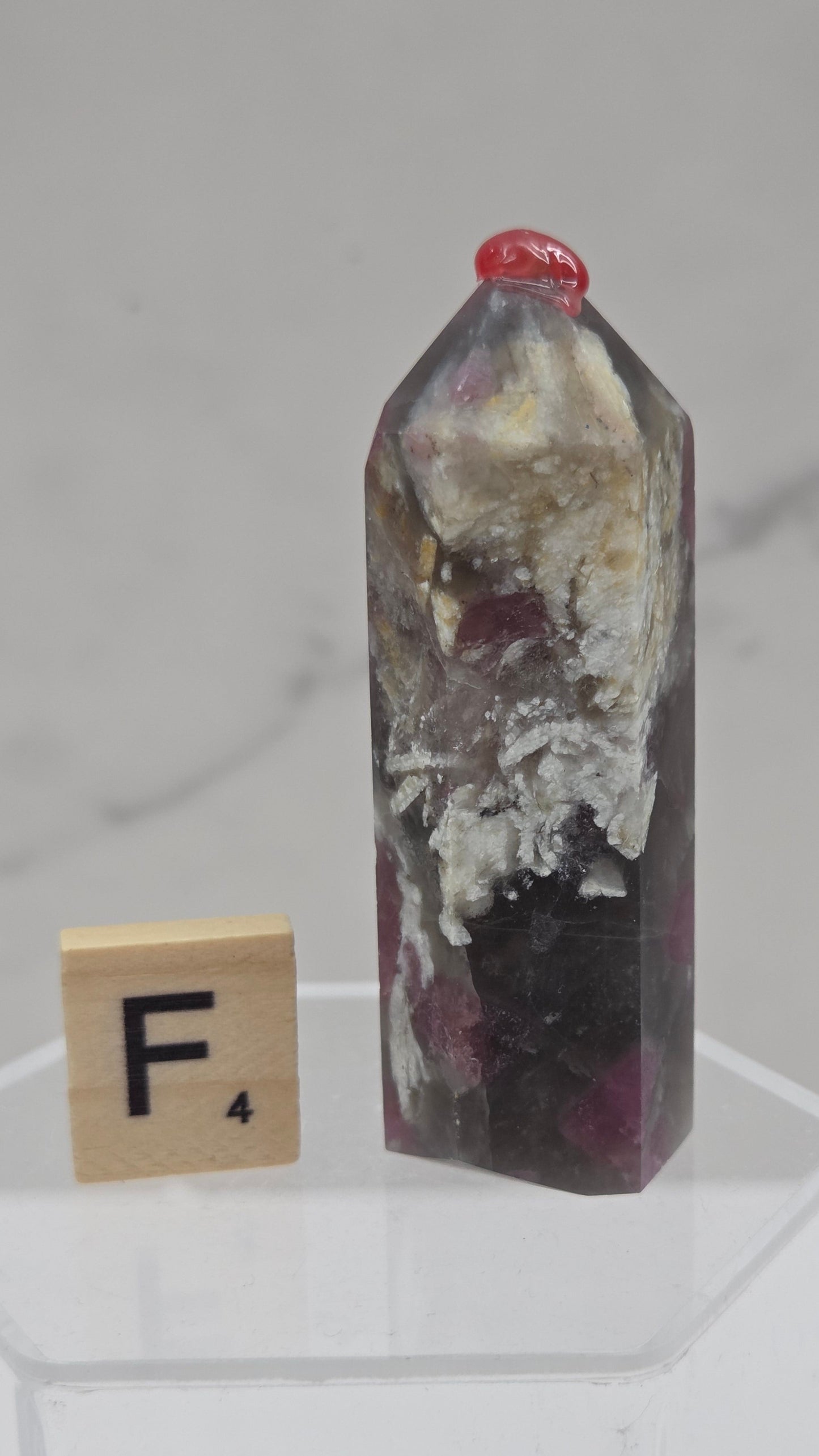 Polished Unicorn Stone crystal towers with varying shades of purple and red, showcasing the natural layered pattern of the stones.