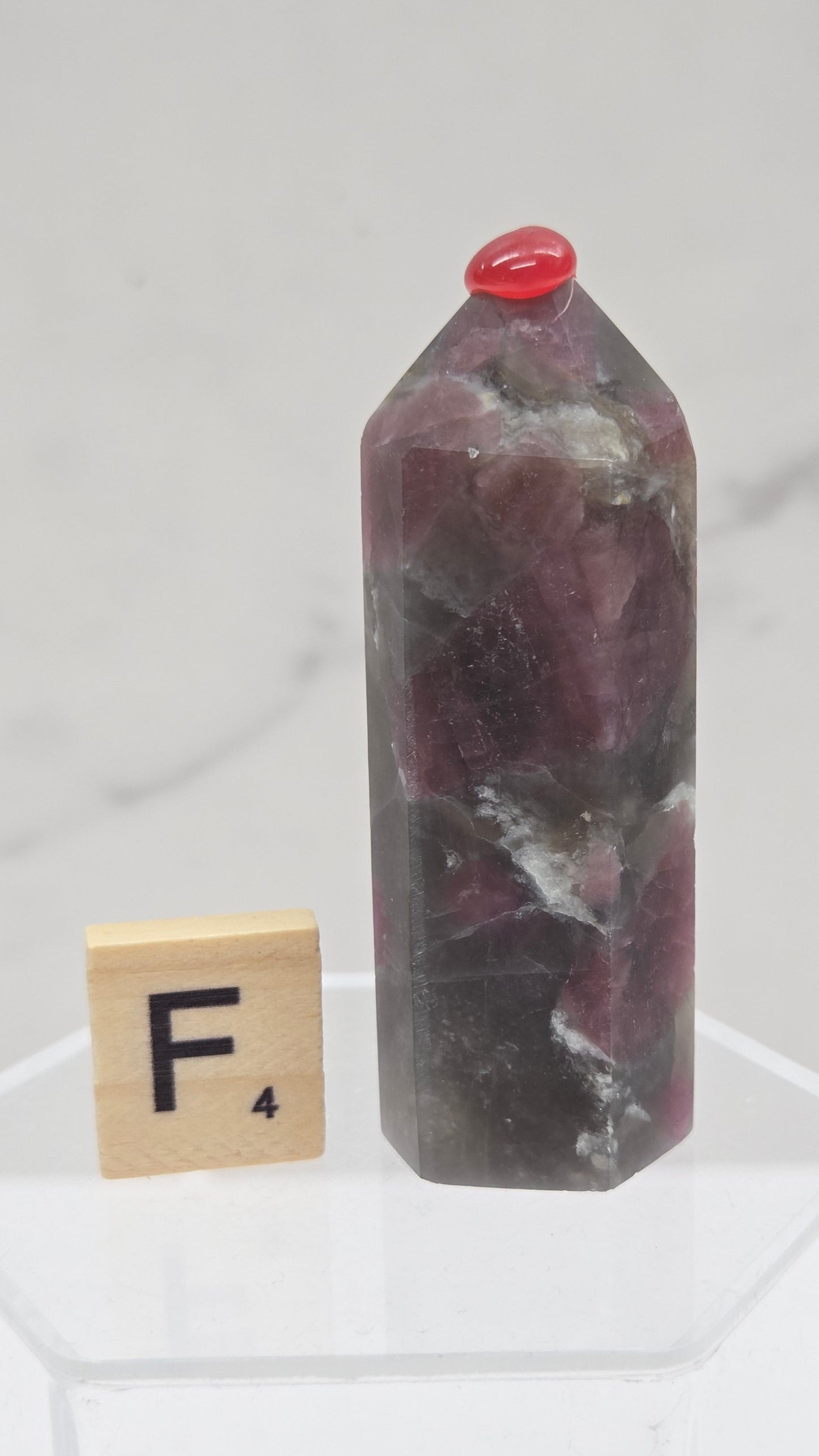 Polished Unicorn Stone crystal towers with varying shades of purple and red, showcasing the natural layered pattern of the stones.