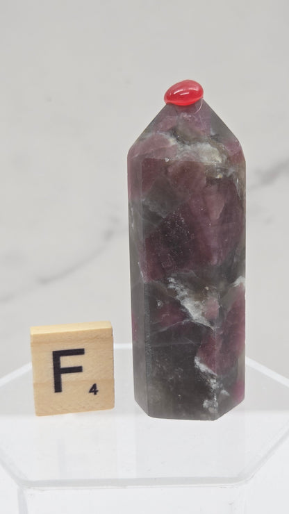 Polished Unicorn Stone crystal towers with varying shades of purple and red, showcasing the natural layered pattern of the stones.