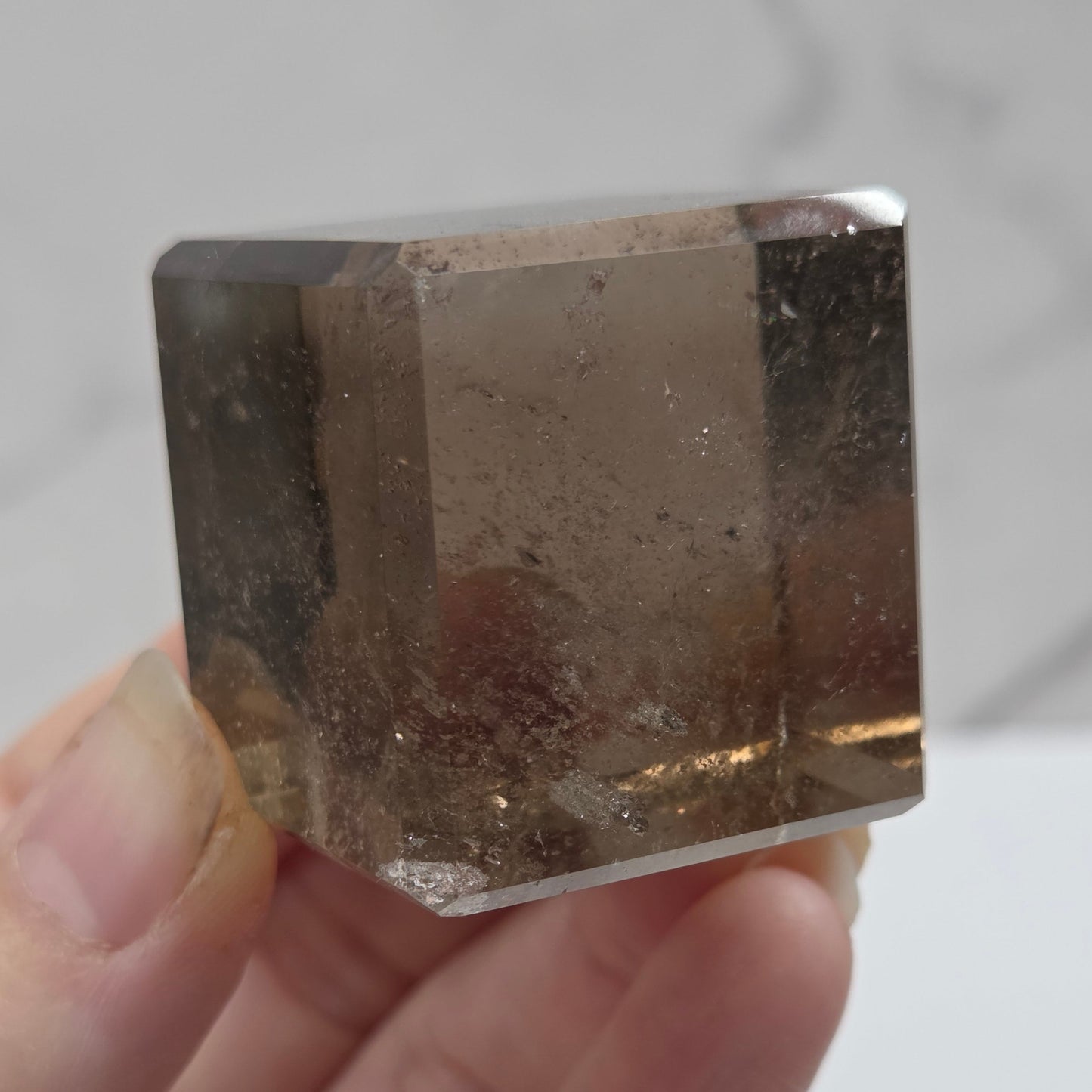 smoky quartz cube carving on a white background
