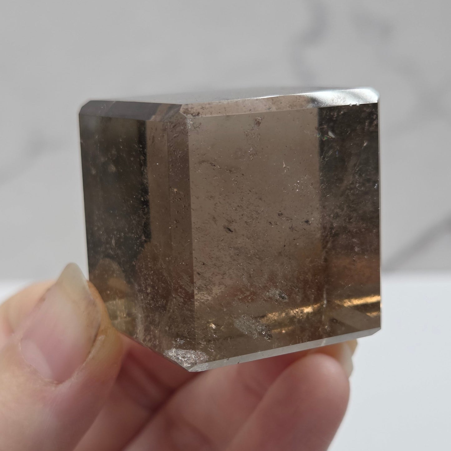 smoky quartz cube carving on a white background
