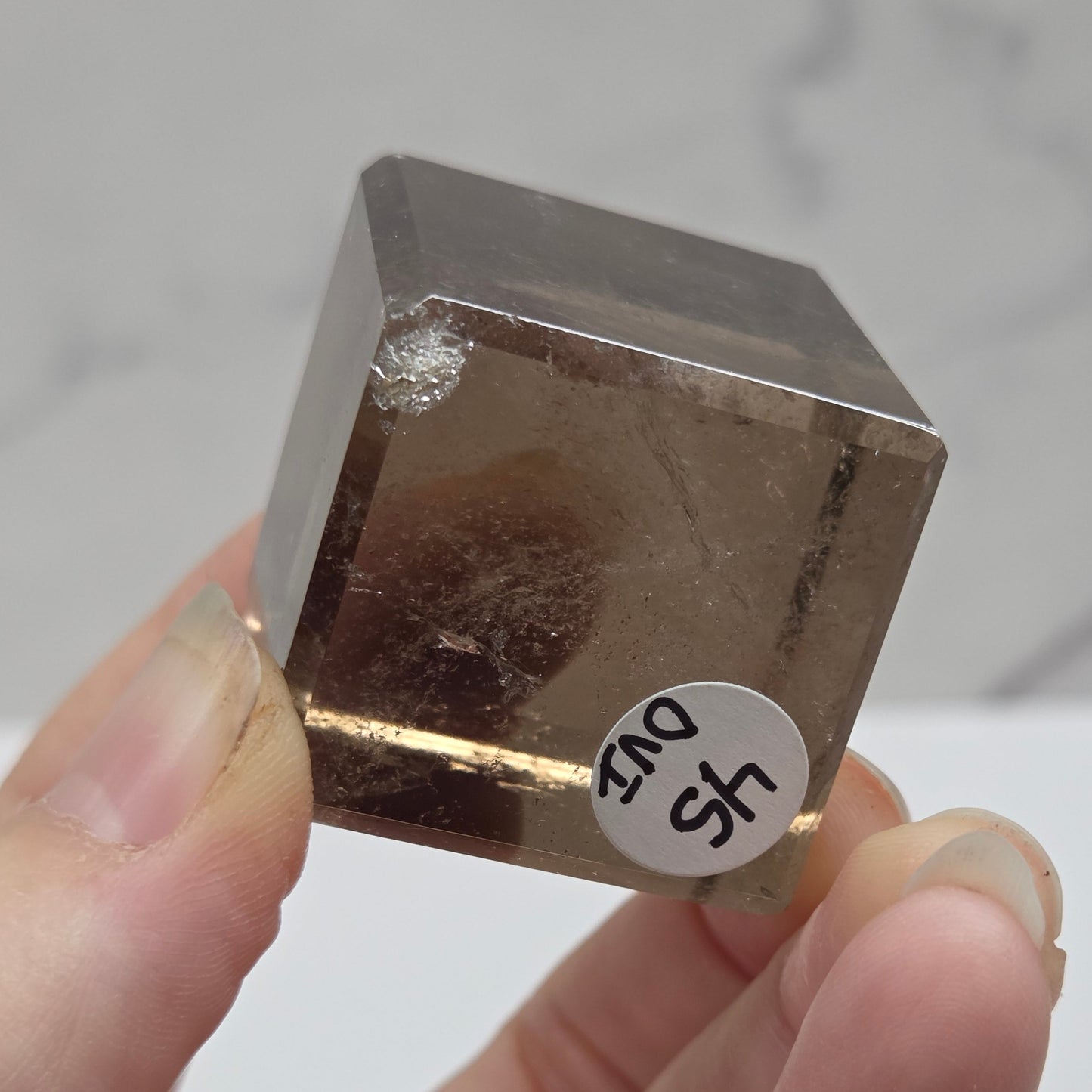 smoky quartz cube carving on a white background
