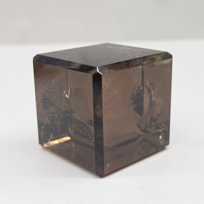 smoky quartz cube carving on a white background