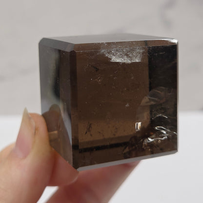 smoky quartz cube carving on a white background