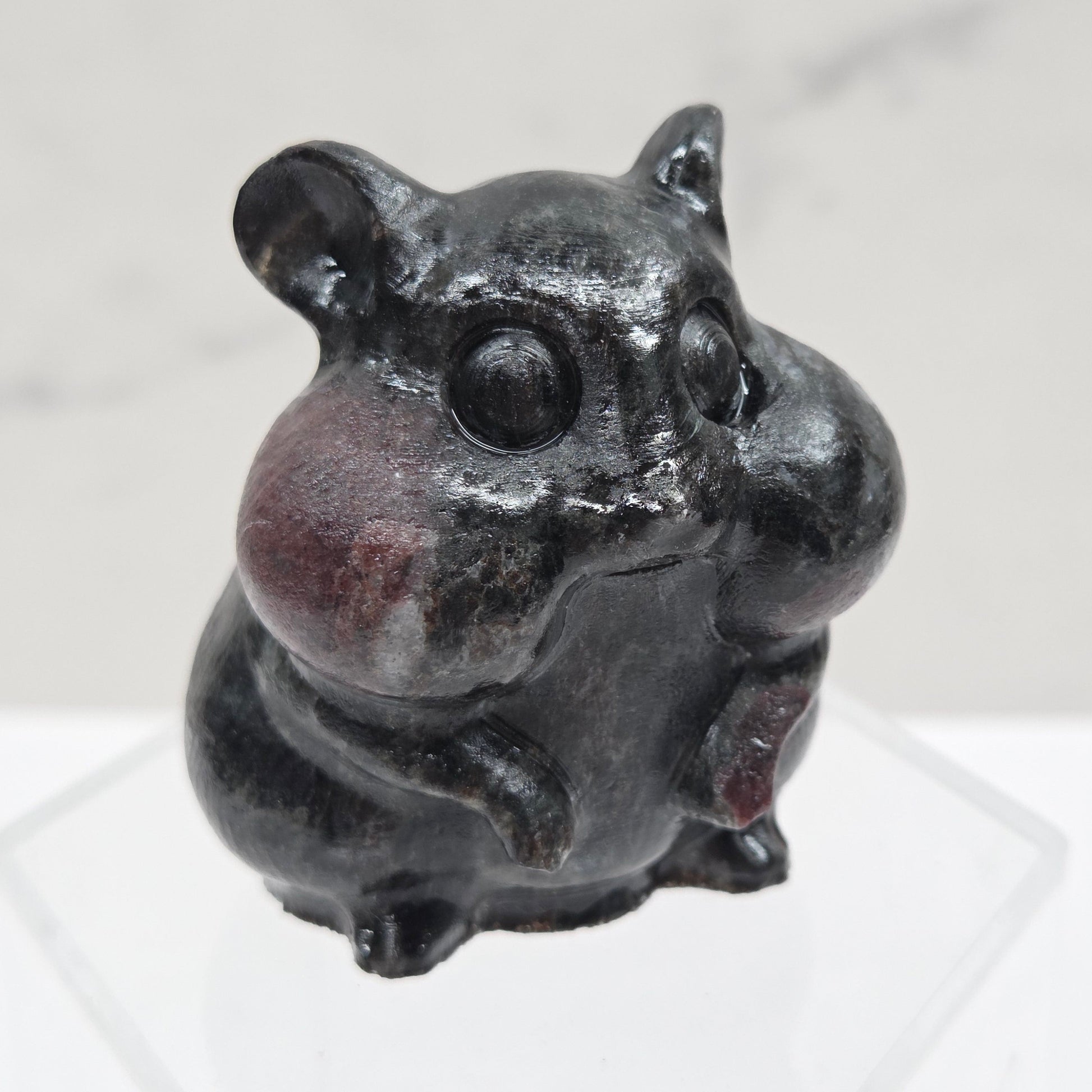 Garnet carving of a chipmunk on an acrylic block against a white background