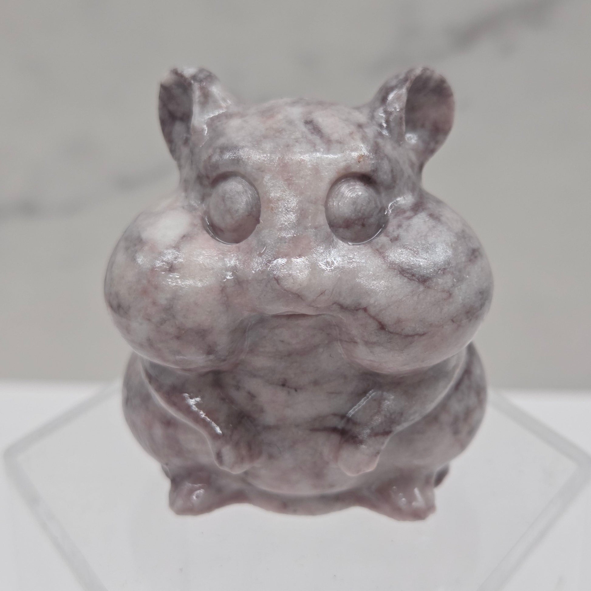 Lavender Jasper carving of a chipmunk on an acrylic block against a white background
