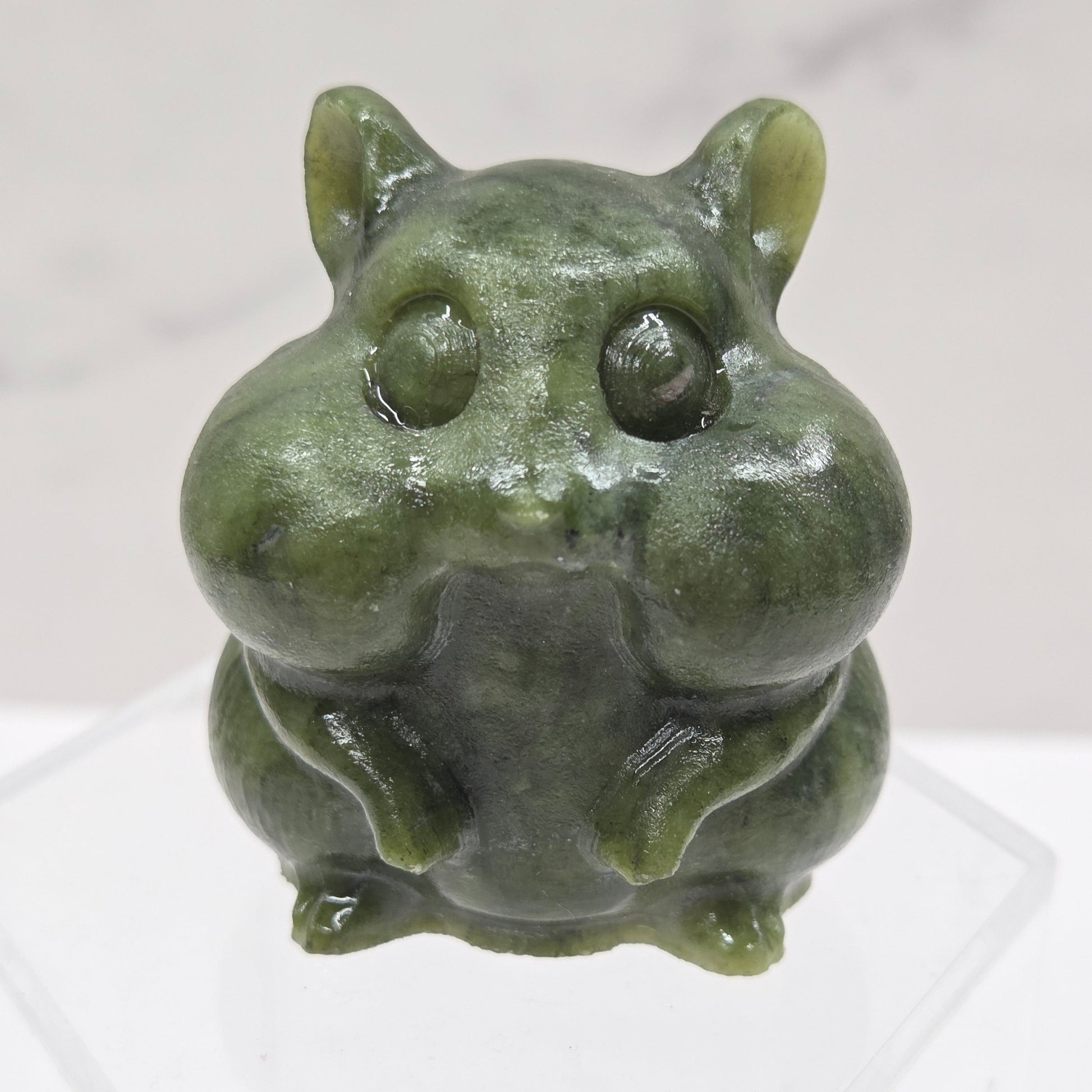 Green Jade carving of a chipmunk on an acrylic block against a white background