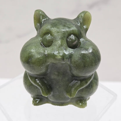 Green Jade carving of a chipmunk on an acrylic block against a white background