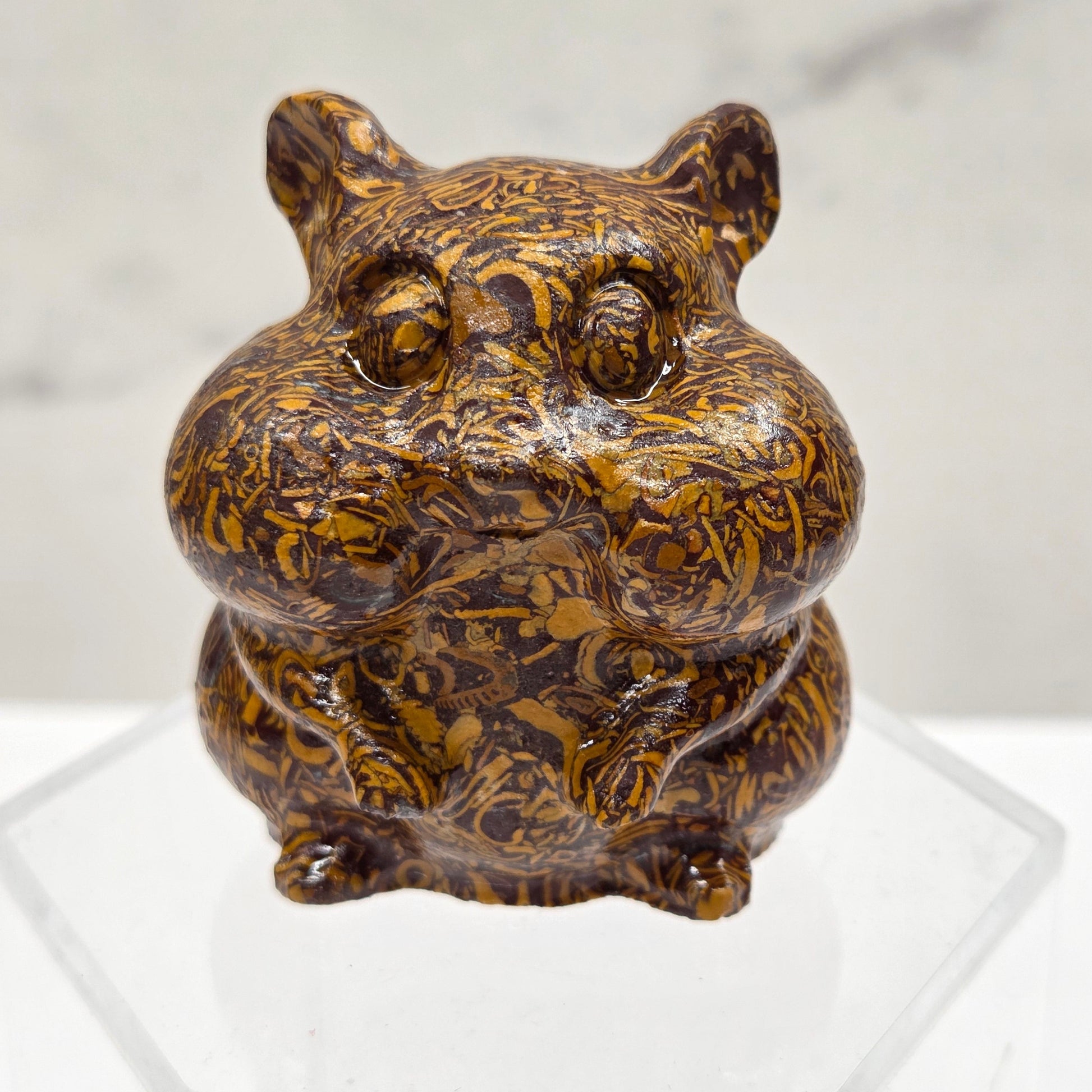 Calligraphy Jasper carving of a chipmunk on an acrylic block against a white background