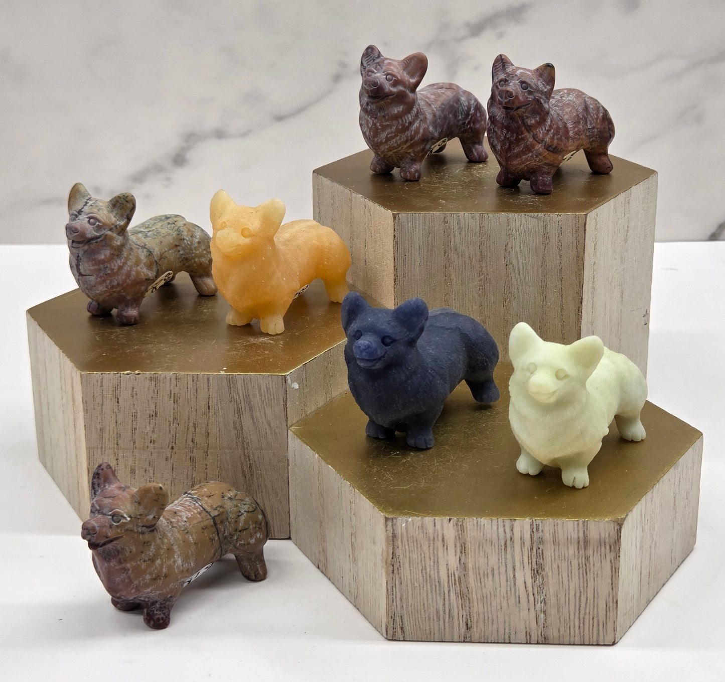 Crystal dog carvings in a variety of colors on a wooden stand against a neutral background