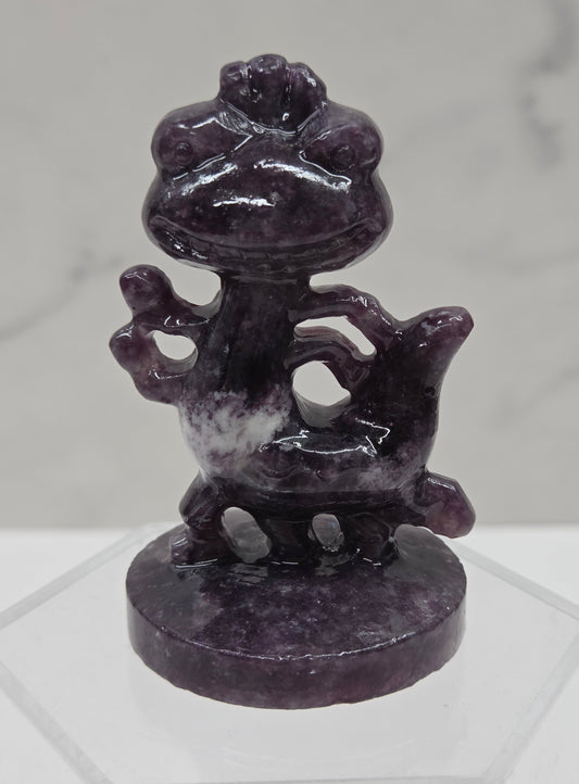 Lepidolite carving of Randall, from Monsters Inc, on an acrylic stand against a white background