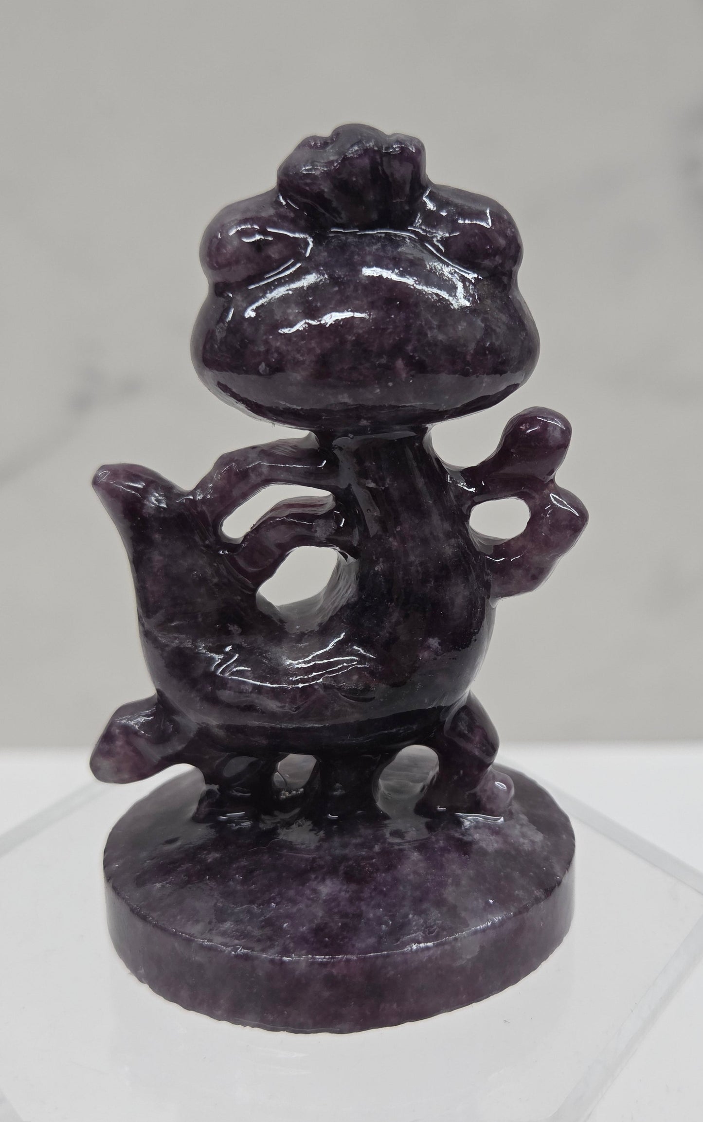 Lepidolite carving of Randall, from Monsters Inc, on an acrylic stand against a white background