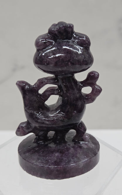 Lepidolite carving of Randall, from Monsters Inc, on an acrylic stand against a white background