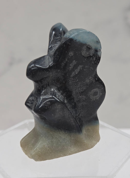 Small stone carving of a fairy on a white background