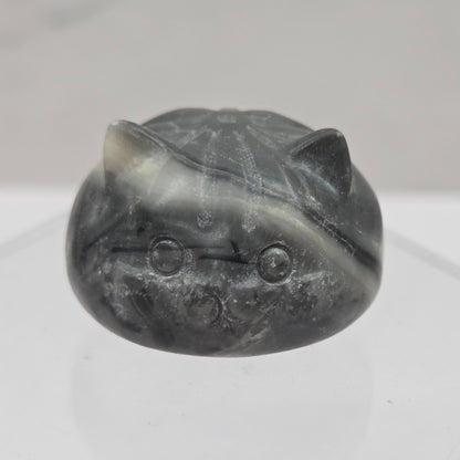 Carved stone object resembling a cat on a white background