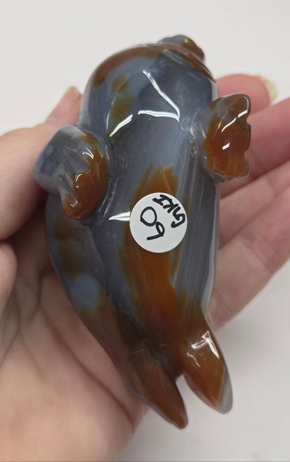 Hand holding a small small crystal figurine with a white background