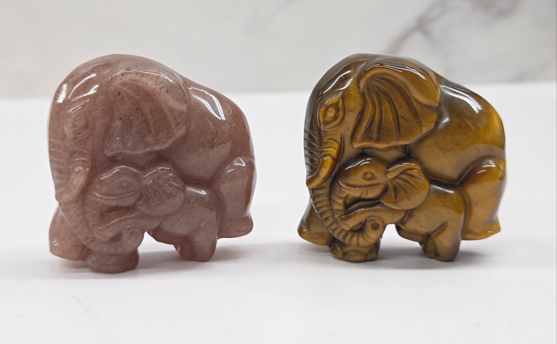 elephant with baby crystal carvings in pink and tan on a neutral background