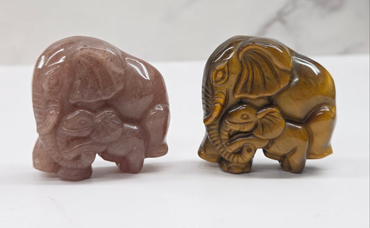 elephant with baby crystal carvings in pink and tan on a neutral background