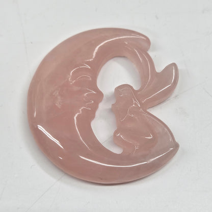 Pink rose quartz fairy on a moon against a neutral background