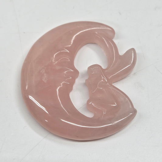 Pink rose quartz fairy on a moon against a neutral background