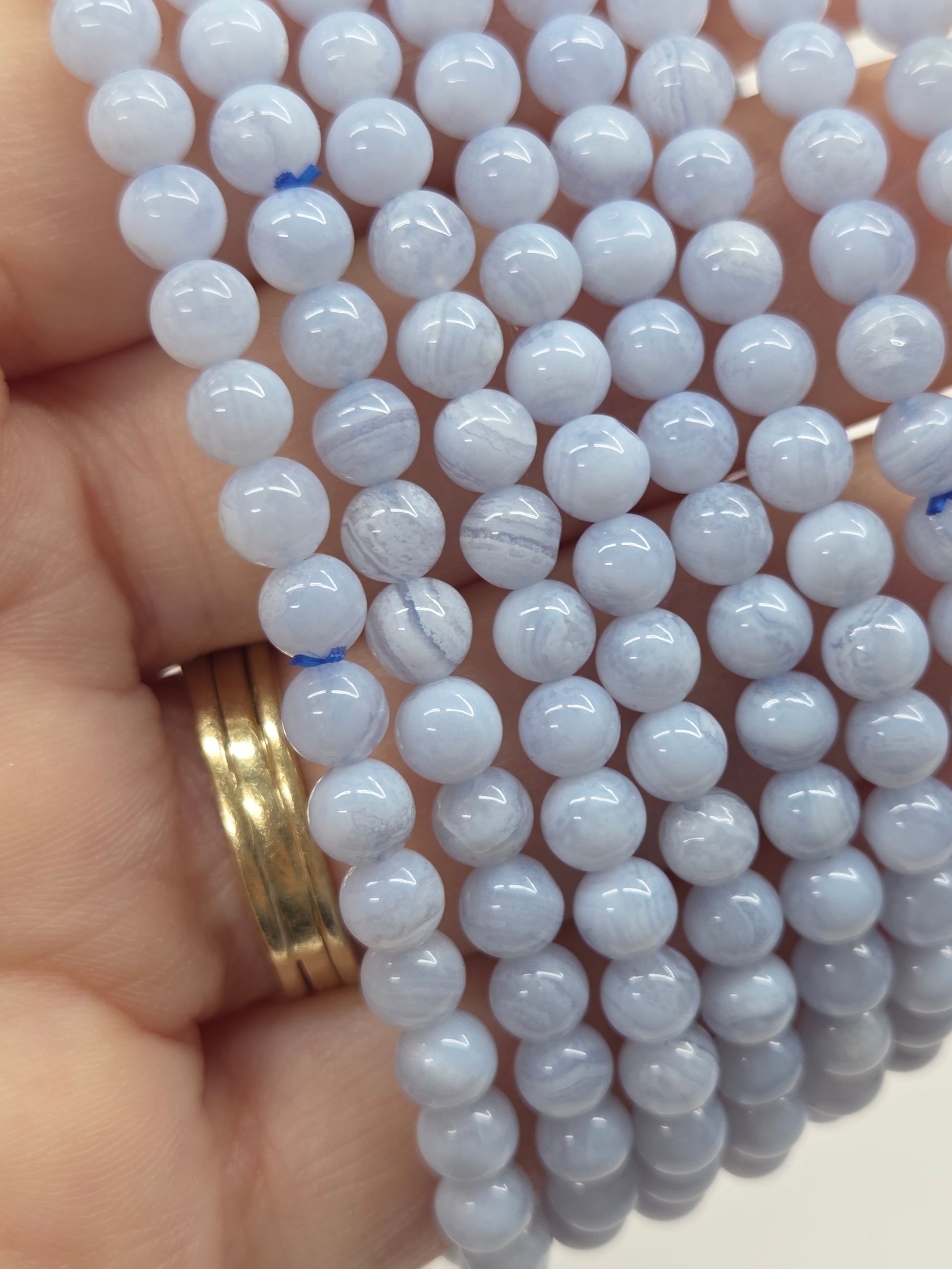 Close-up of a strand of light blue beads held by a hand