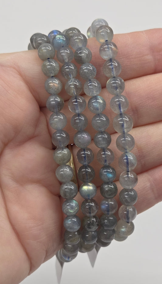 Beaded bracelets on a hand against a plain background