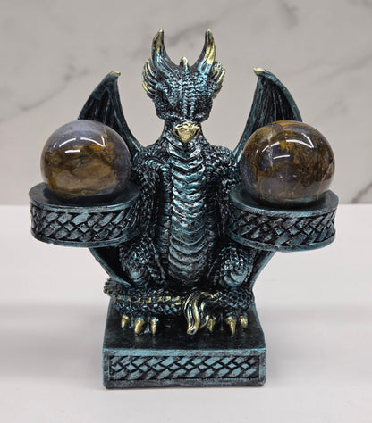 Decorative dragon-shaped sphere holder with 2 small spheres on a marble surface