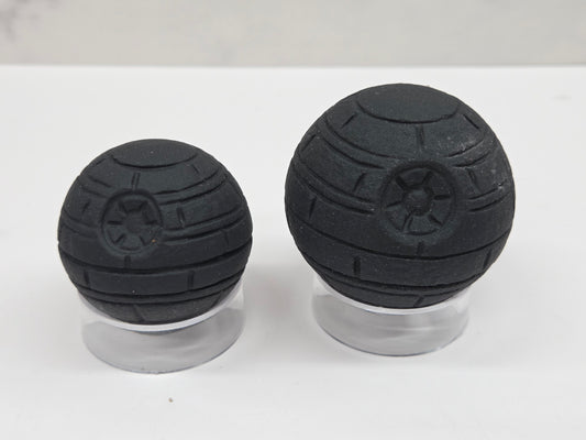 Obsidian carving of the Death Star from star wars, on acrylic stands against a white background
