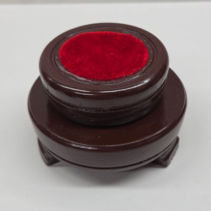 Round wood sphere holder with red velvet on a neutral background